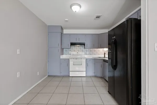 a kitchen with a stove a refrigerator and a sink