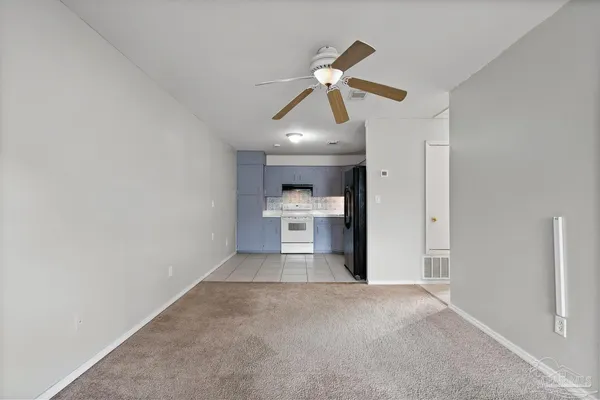 a view of a kitchen and an empty room