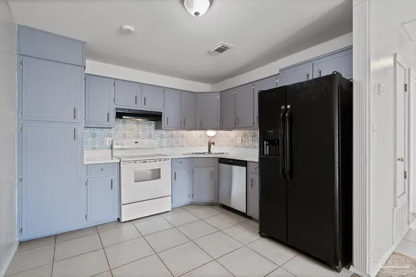 a kitchen with white cabinets and white appliances
