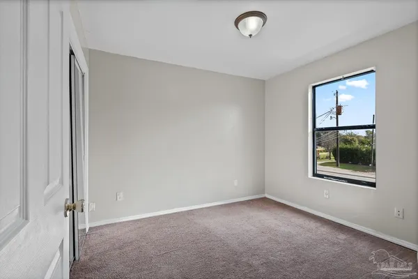 an empty room with windows and closet
