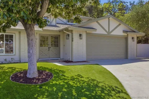a front view of a house with a yard and trees