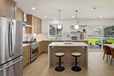 a kitchen with stainless steel appliances granite countertop a sink a stove and a refrigerator