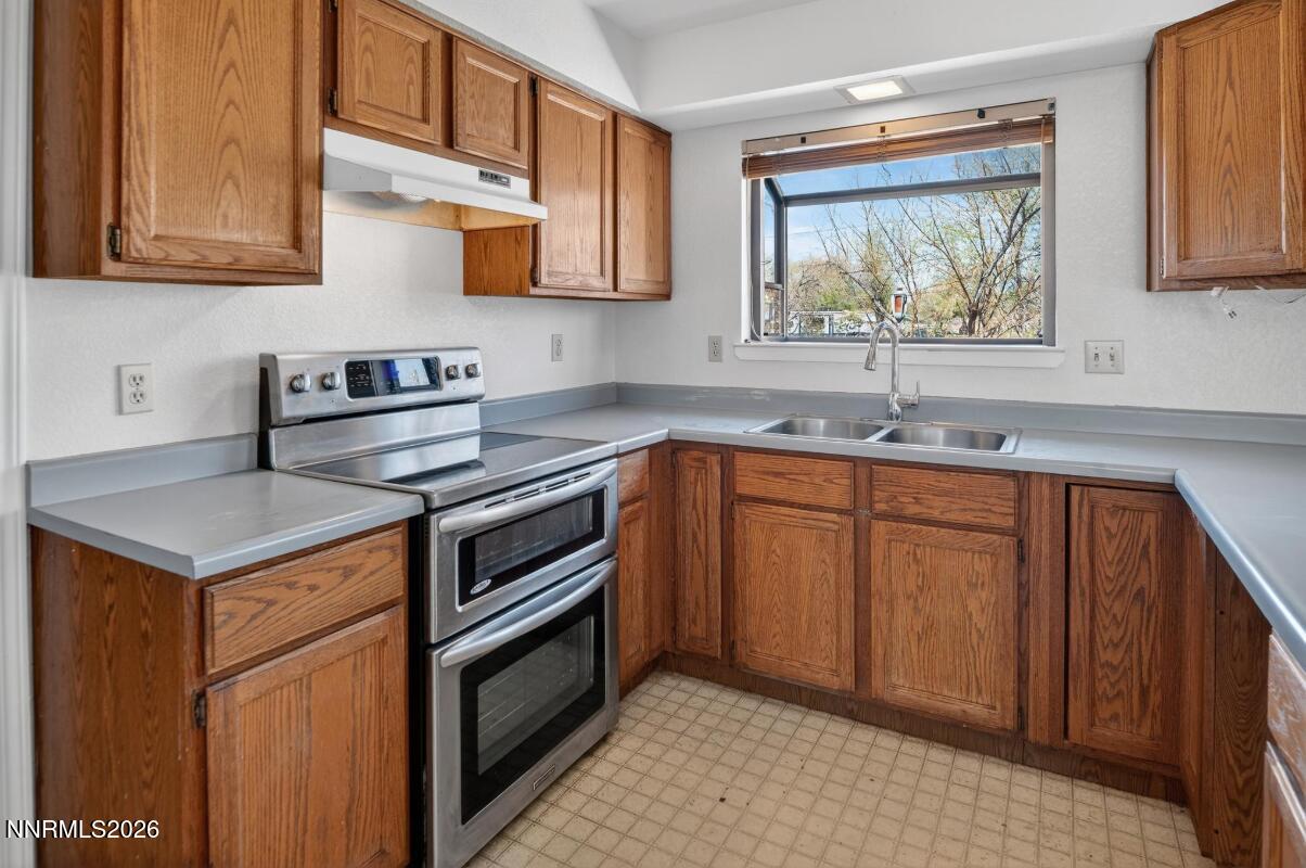 1254 Stephanie Way Minden, NV 89423 - Photo 14 of 30 a kitchen with stainless steel appliances granite countertop a sink stove and cabinets