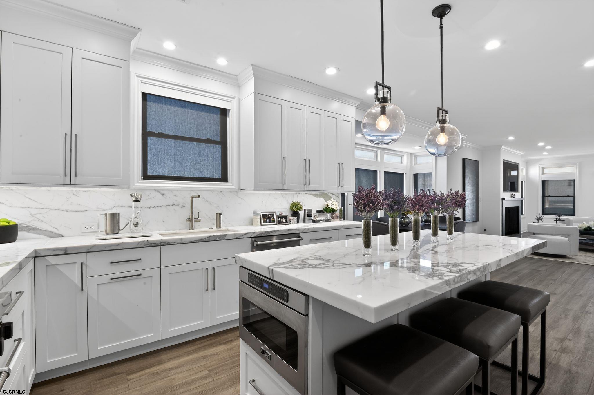 146 Ridgeway Avenue Atlantic City, NJ 08401 - Photo 9 of 59 a kitchen with kitchen island granite countertop a sink a center island and cabinets