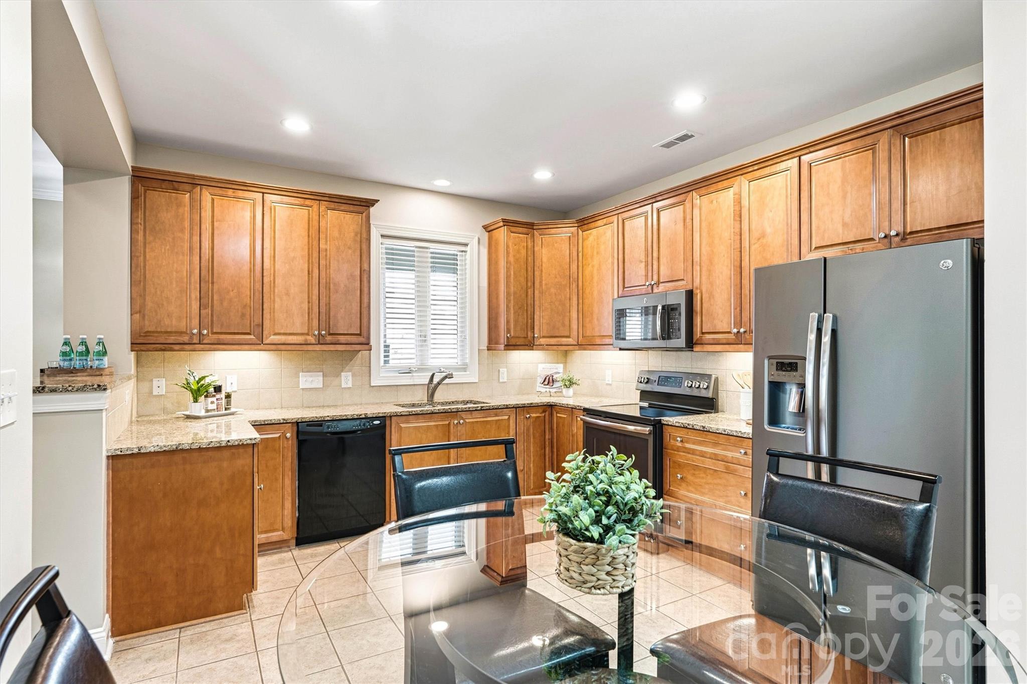 2830 Bellasera Way Matthews, NC 28105 - Photo 12 of 40 a kitchen with granite countertop appliances cabinets and a refrigerator