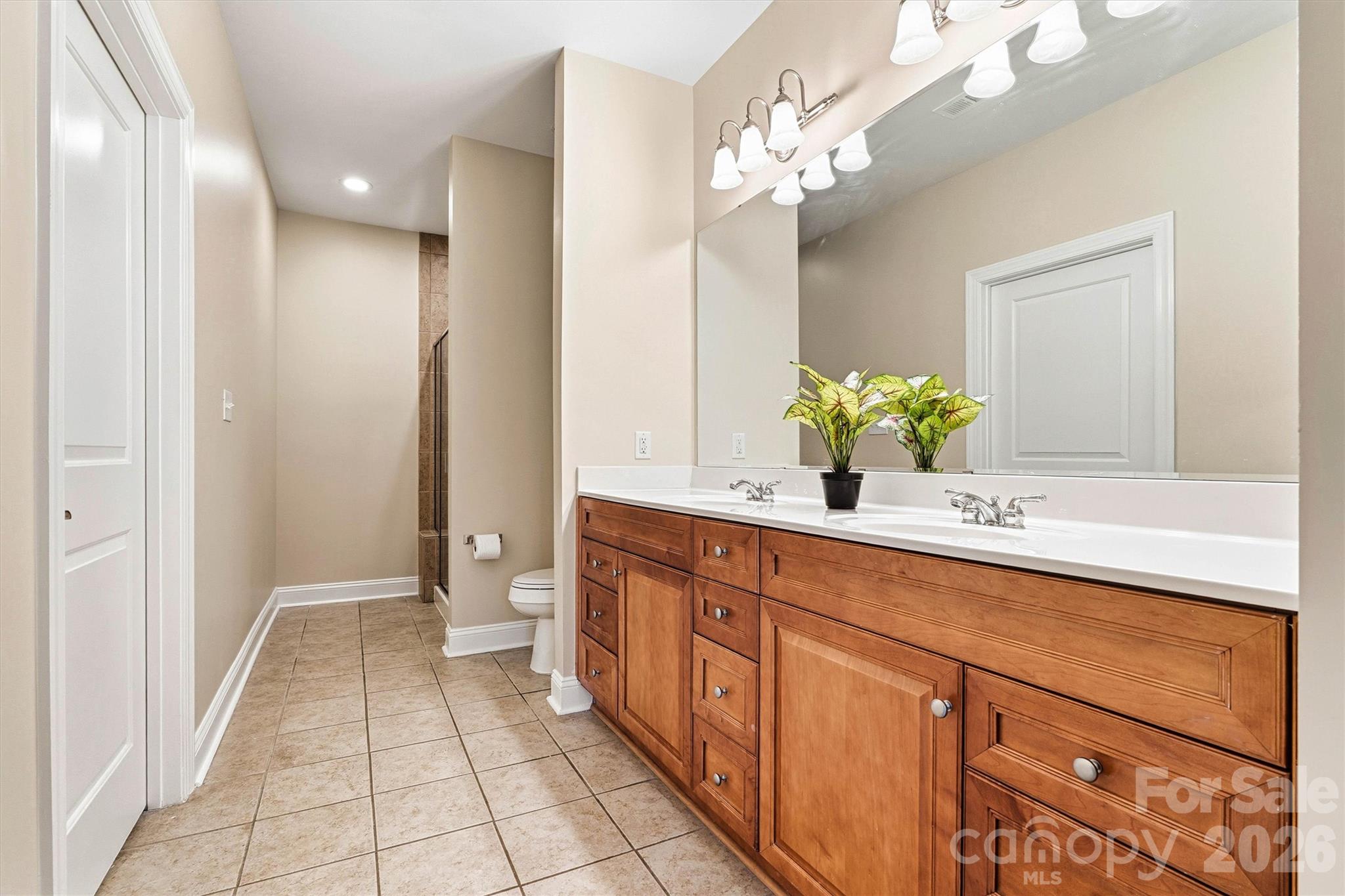 2830 Bellasera Way Matthews, NC 28105 - Photo 23 of 40 a spacious bathroom with a granite countertop double vanity and a mirror