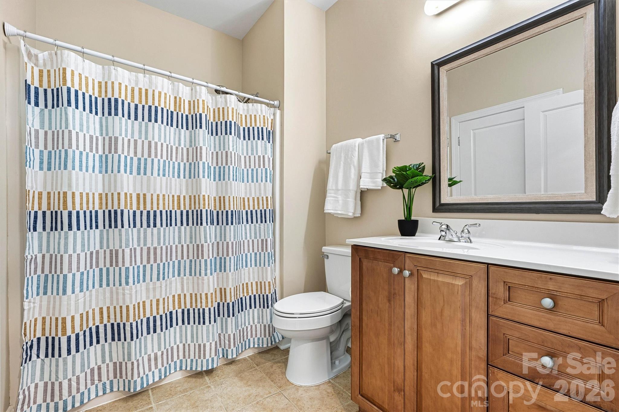 2830 Bellasera Way Matthews, NC 28105 - Photo 29 of 40 a bathroom with a sink a toilet and shower curtain
