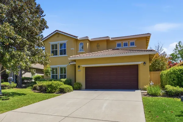 a front view of a house with yard and garage