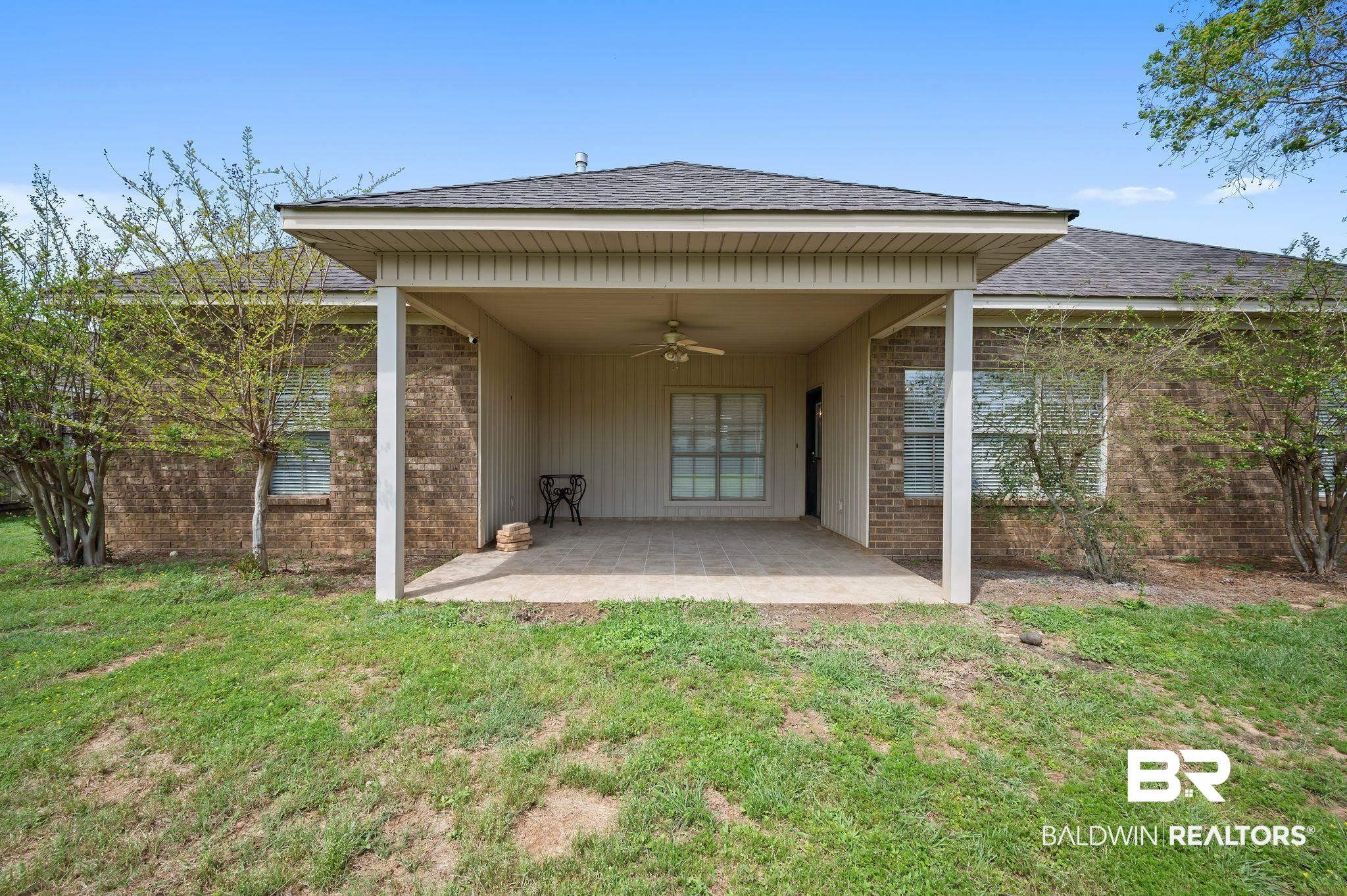 9837 Harmony Ridge Drive Semmes, AL 36575 - Photo 27 of 29 Rear view of house featuring a patio area, roof with shingles, a ceiling fan, brick siding, and a lawn