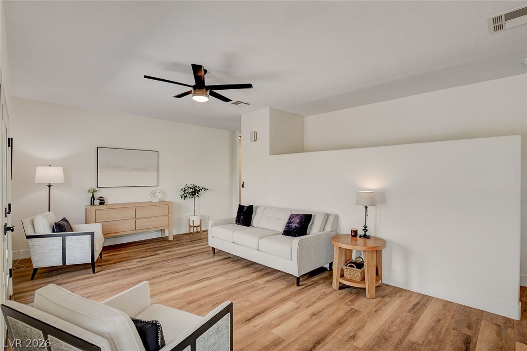 4362 Thistle Street Logandale, NV 89021 - Photo 13 of 99 An inviting living room features warm LVP floors and a modern ceiling fan.