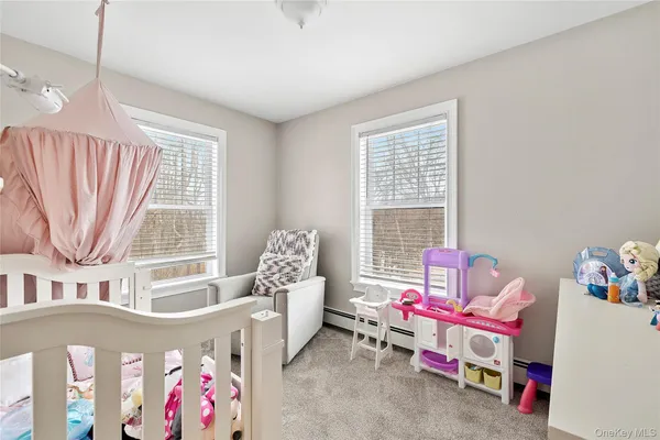 a bedroom with baby bed toys and paintings on the wall