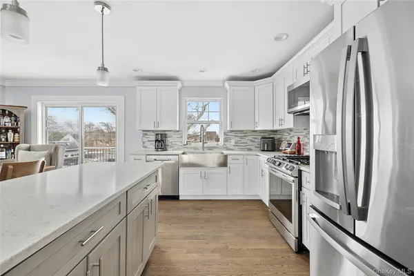 a kitchen with white cabinets and stainless steel appliances