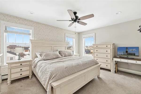 a living room with furniture a flat screen tv and a large window