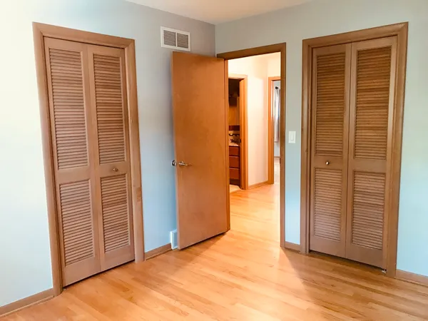 an empty room with windows and closet area