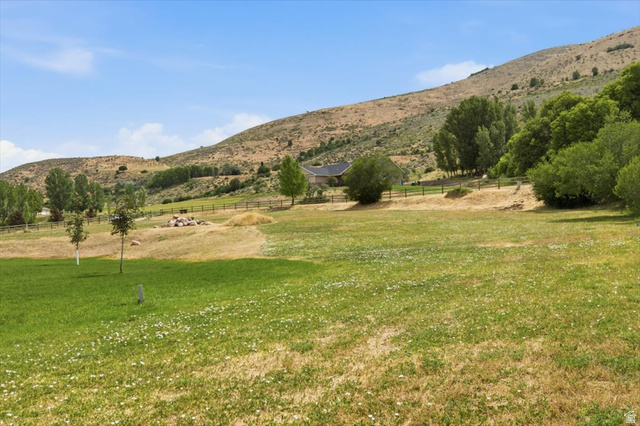 3123 East Riverdale Road Preston, ID 83263 - Photo 35 of 52 Expansive property featuring varied terrain, a distant residence with a dark roof, mature trees, and a partial perimeter fence