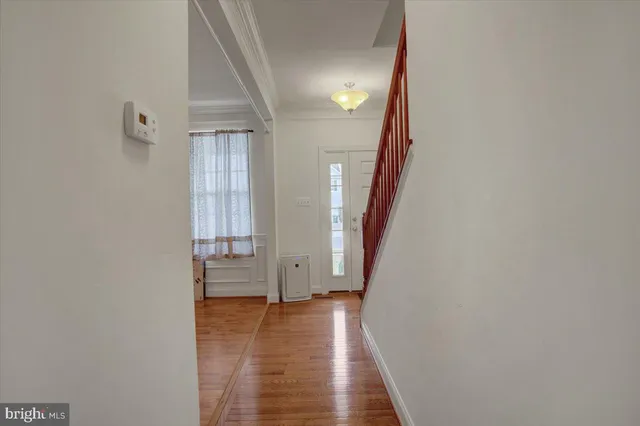 a view of a hallway with wooden floor and staircase