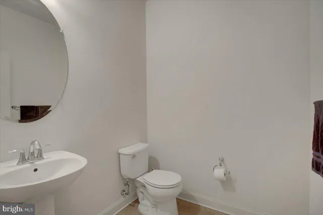 a bathroom with a toilet a sink and mirror