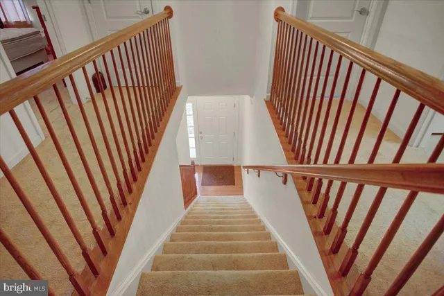 a view of staircase with railing and white floor