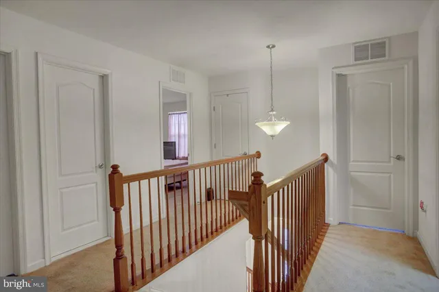a view of a hallway with chandelier and entryway