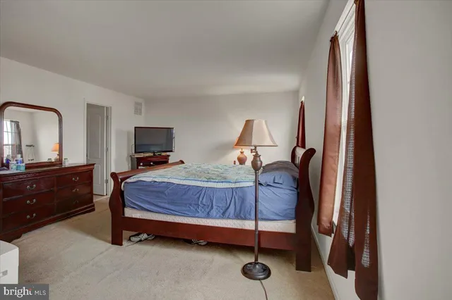 a bedroom with a bed and a mirror on dresser