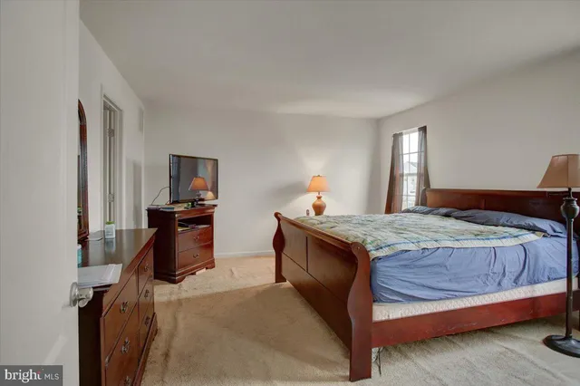 a bedroom with a bed and a flat tv screen on dresser