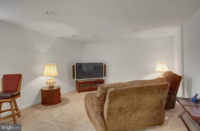 a living room with furniture a flat screen tv and a window