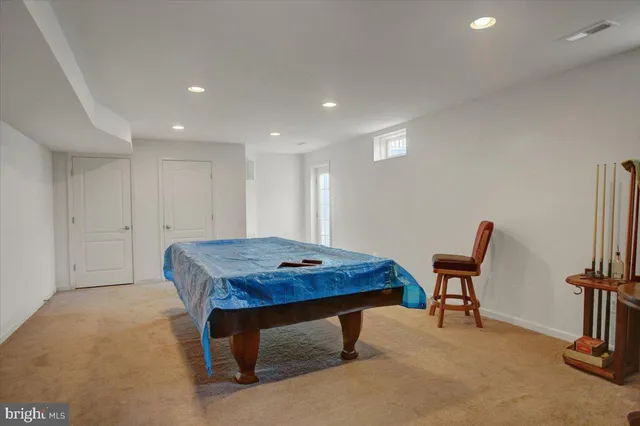 a room with furniture pool table and a rug