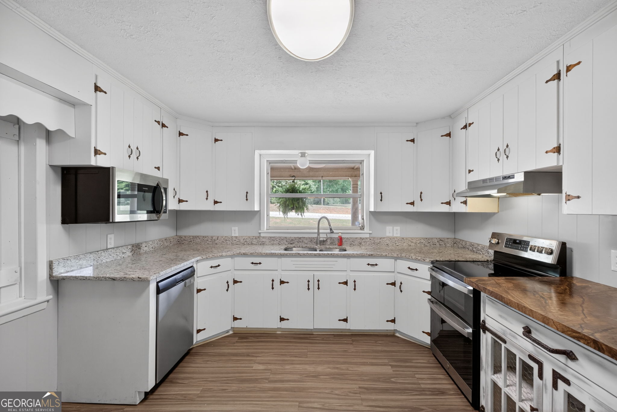 1861 Highway 100 Bowdon, GA 30108 - Photo 12 of 35 a kitchen with stainless steel appliances granite countertop a stove a sink and a refrigerator