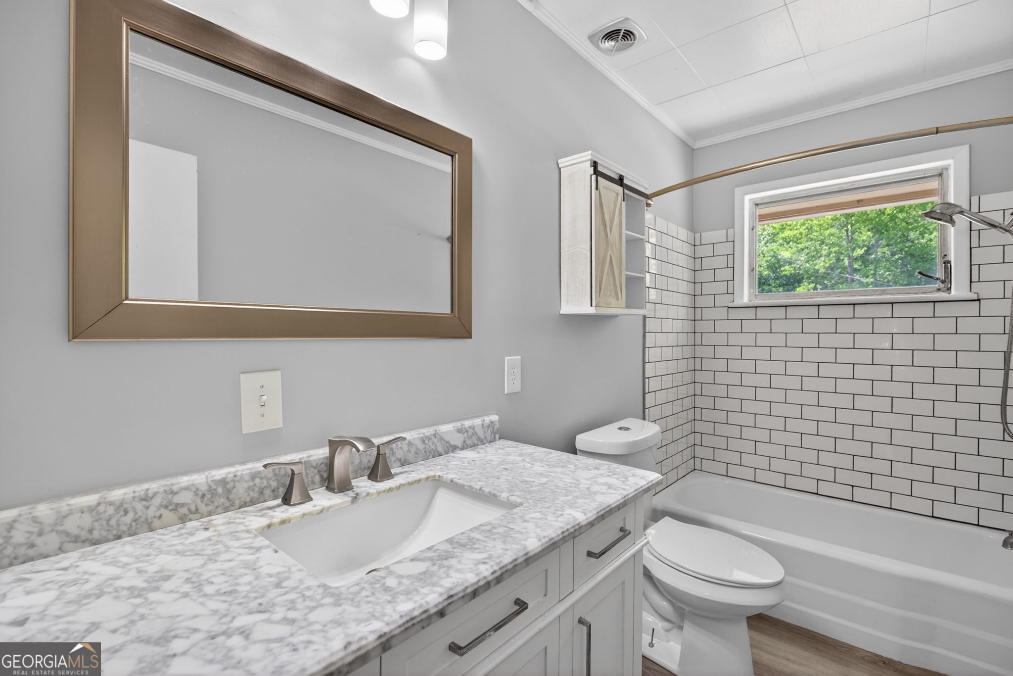 1861 Highway 100 Bowdon, GA 30108 - Photo 25 of 35 a bathroom with a granite countertop toilet a sink and a mirror