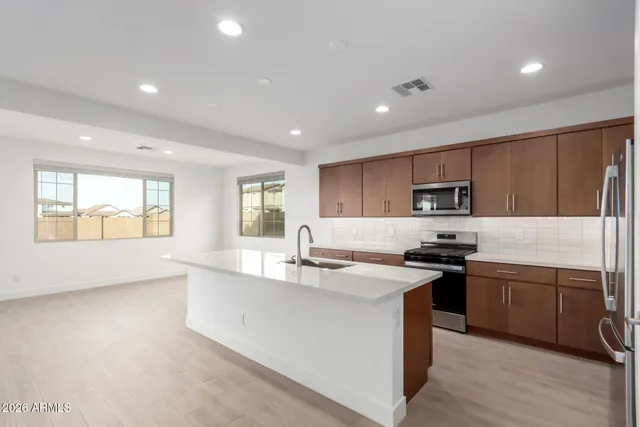 a kitchen with stainless steel appliances a refrigerator sink and white cabinets