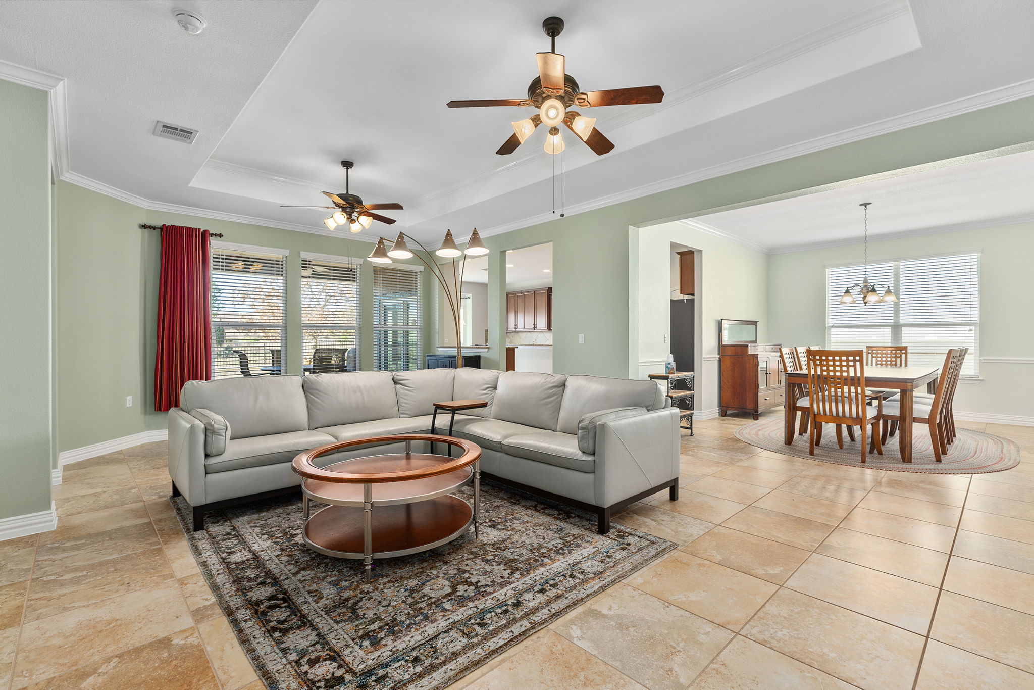 110 Emory Peak Trail Georgetown, TX 78633 - Photo 11 of 39 Living area featuring a tray ceiling, crown molding, and a ceiling fan