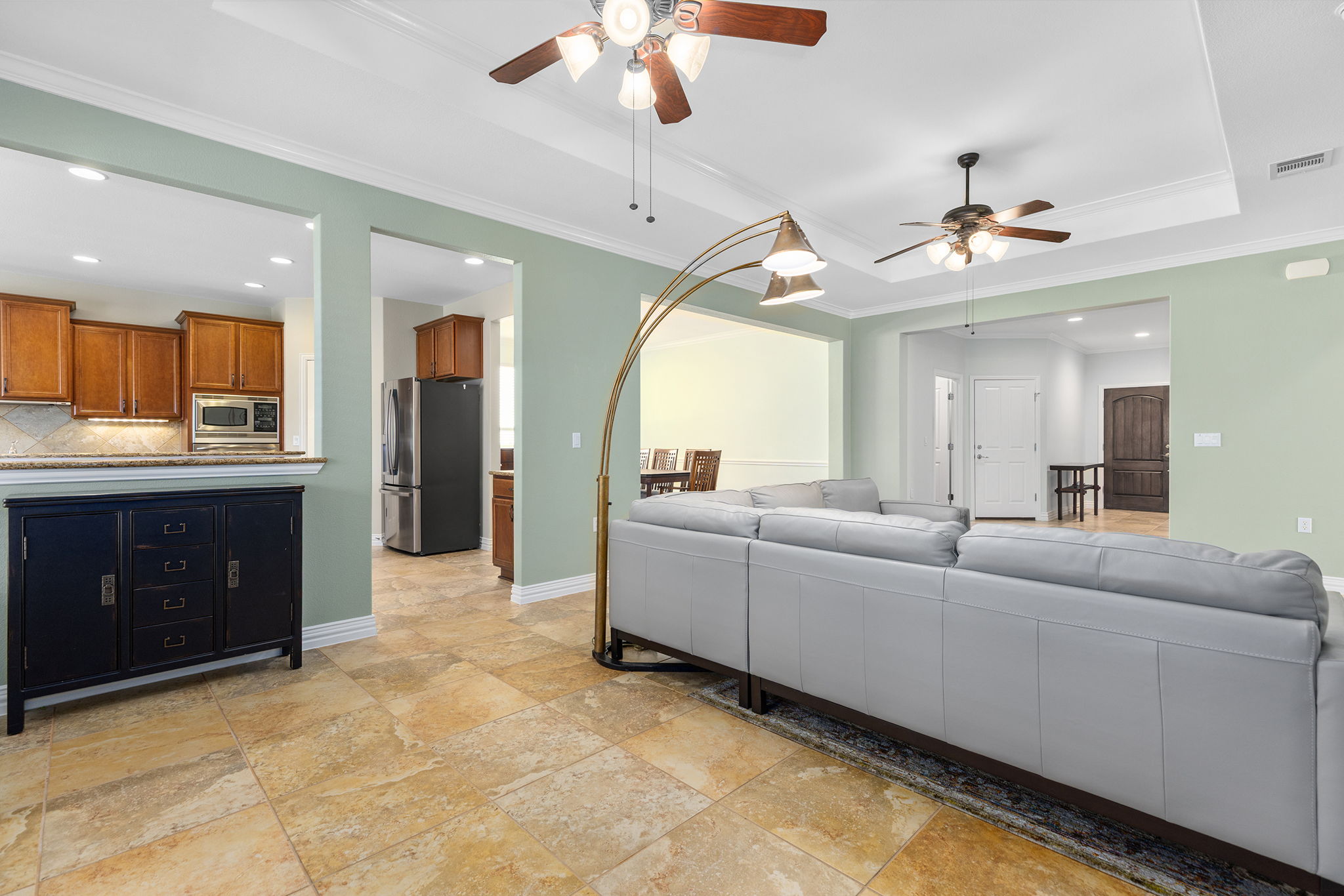 110 Emory Peak Trail Georgetown, TX 78633 - Photo 12 of 39 Living room with ornamental molding, a tray ceiling, ceiling fan, recessed lighting, and stone tile flooring