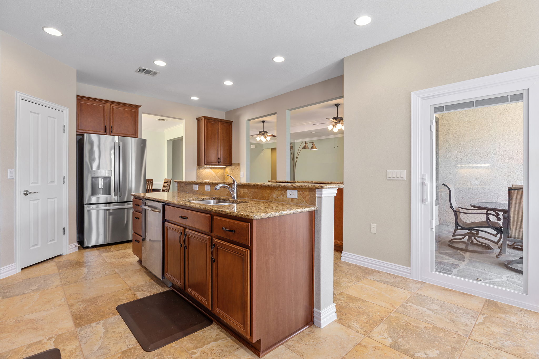 110 Emory Peak Trail Georgetown, TX 78633 - Photo 17 of 39 Kitchen featuring light stone counters, appliances with stainless steel finishes, an island with sink, brown cabinets, and recessed lighting