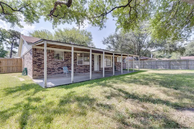 a view of a yard with large trees and a barn in it