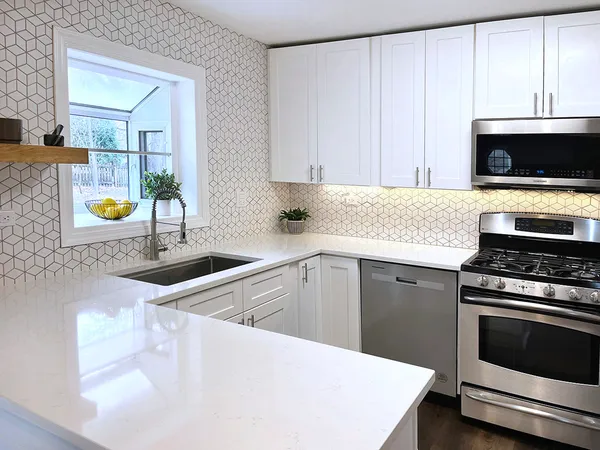 a kitchen with white cabinets and appliances
