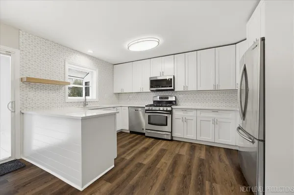 a kitchen with a sink cabinets and wooden floor