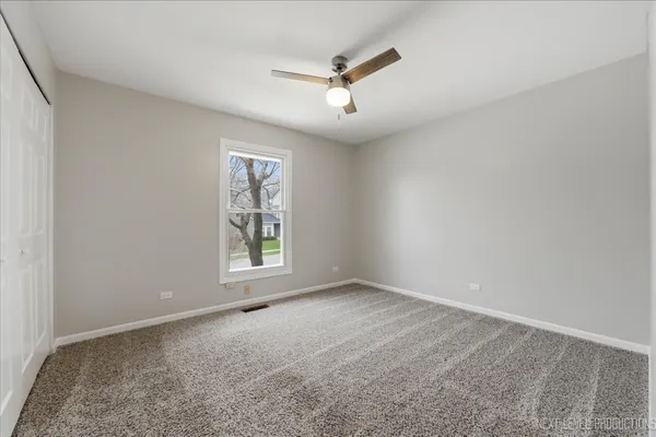 a view of empty room with wooden floor and fireplace