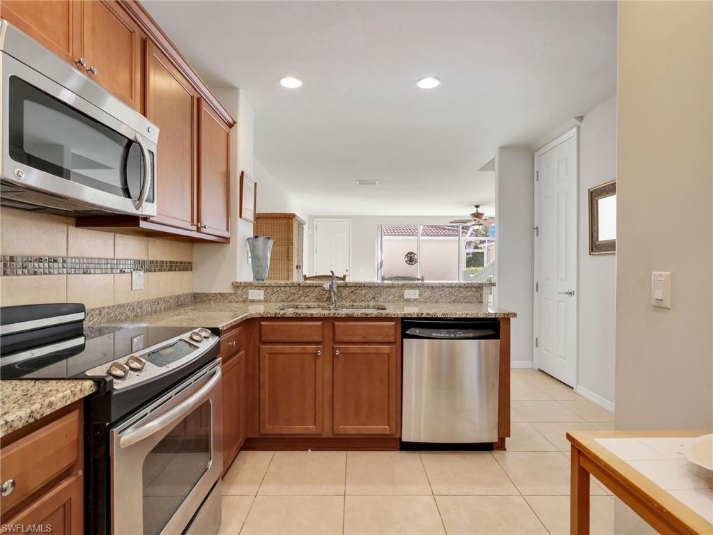 8192 Josefa Way Naples, FL 34114 - Photo 3 of 29 a kitchen with stainless steel appliances granite countertop a stove a sink and a microwave
