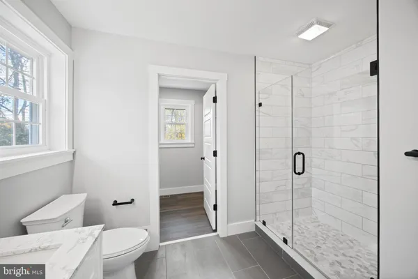 a bathroom with a shower a toilet and a sink