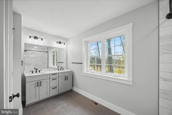 a view of a bathroom with two sink and a window