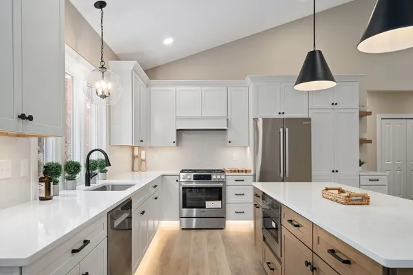 a kitchen with granite countertop a sink a counter space appliances and cabinets