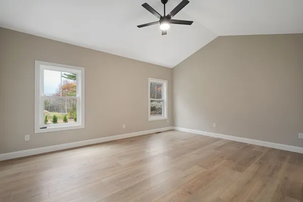 a view of an empty room with a window and wooden floor