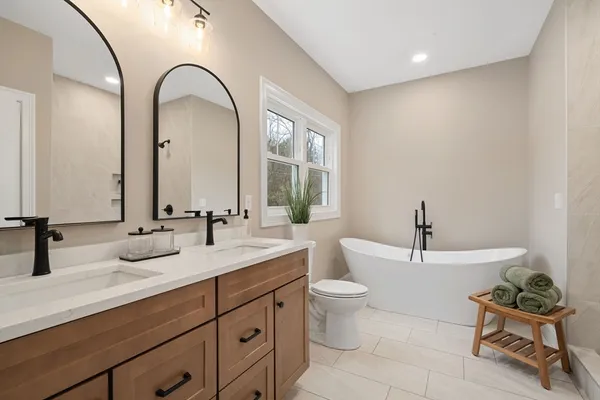 a spacious bathroom with a double vanity sink mirror and bathtub