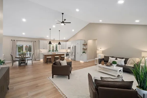 a living room with furniture kitchen view and a chandelier