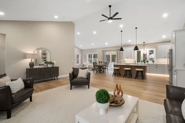 a living room with furniture kitchen view and a chandelier