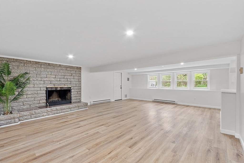 31 Pine Hill Road Chelmsford, MA 01824 - Photo 31 of 42 an empty room with wooden floor fireplace and windows
