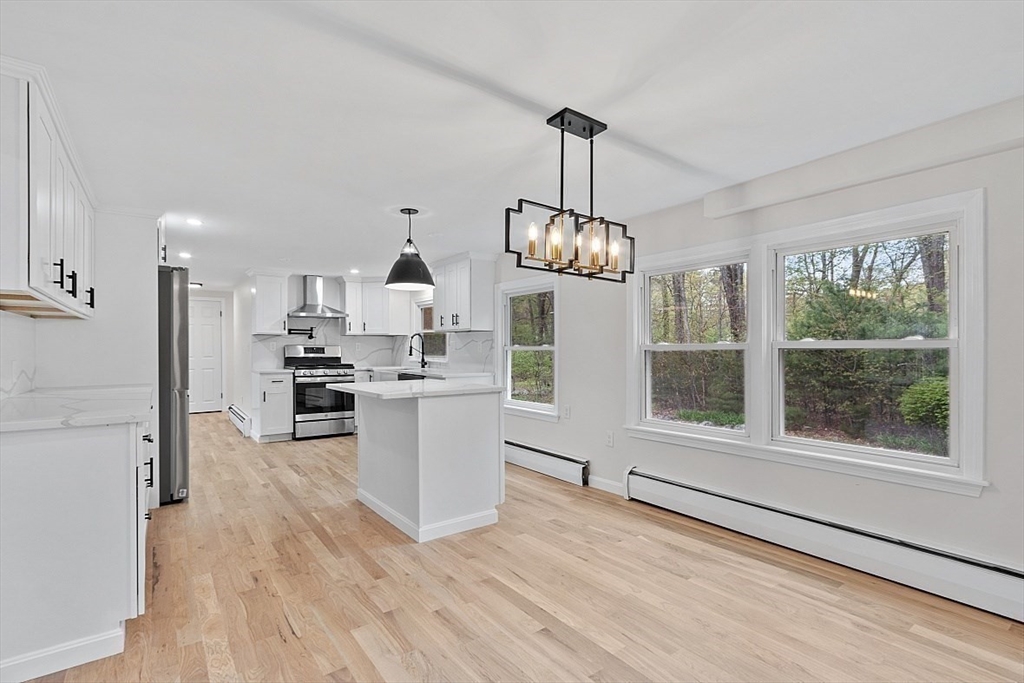 31 Pine Hill Road Chelmsford, MA 01824 - Photo 7 of 42 a view of a kitchen with wooden floor and stainless steel appliances