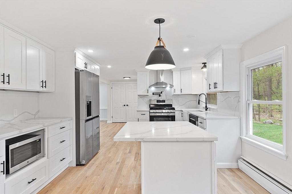 31 Pine Hill Road Chelmsford, MA 01824 - Photo 9 of 42 a kitchen with stainless steel appliances a stove a sink a refrigerator and cabinets