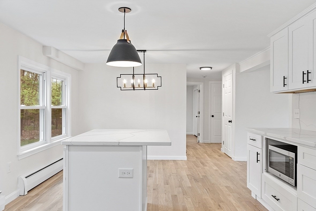 31 Pine Hill Road Chelmsford, MA 01824 - Photo 10 of 42 a kitchen with stainless steel appliances a stove a microwave and white cabinets