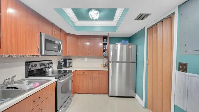 a kitchen with a refrigerator sink and cabinets